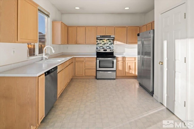 kitchen featuring light countertops, appliances with stainless steel finishes, light brown cabinets, a sink, and under cabinet range hood