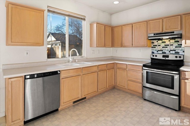 kitchen with stainless steel appliances, light countertops, under cabinet range hood, light brown cabinets, and a sink