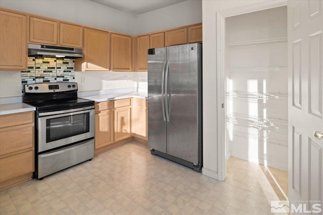 kitchen with light countertops, appliances with stainless steel finishes, light floors, and under cabinet range hood