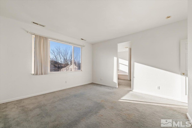 unfurnished room with light carpet, visible vents, and baseboards