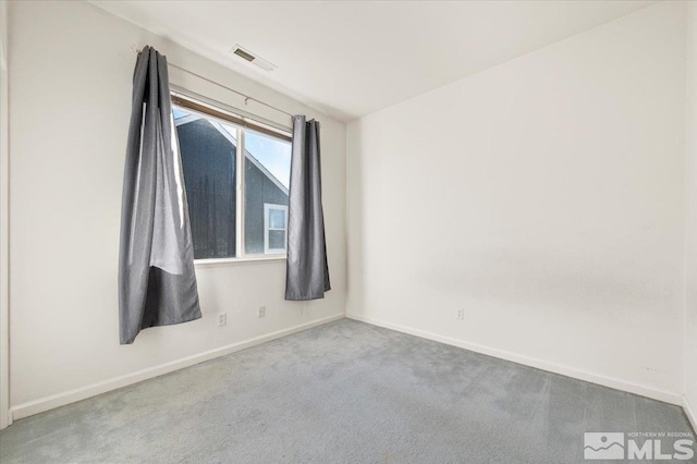 spare room featuring baseboards, visible vents, and carpet flooring