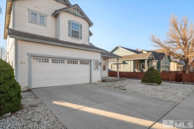 view of front of home featuring concrete driveway, an attached garage, and fence