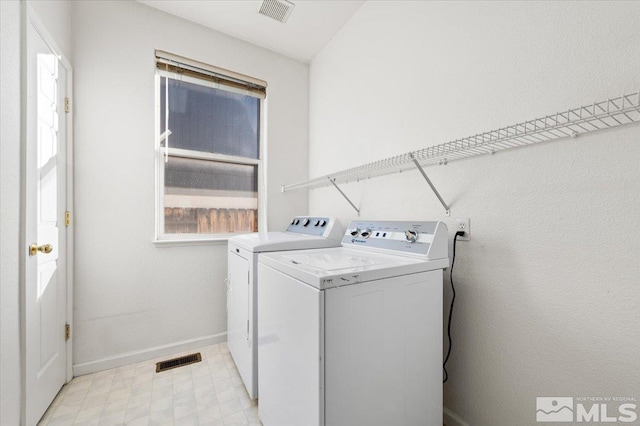 laundry room with laundry area, baseboards, visible vents, and washer and clothes dryer