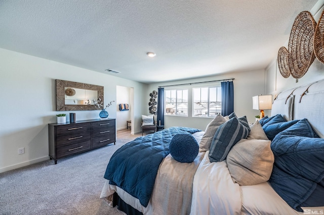 bedroom featuring baseboards, visible vents, a textured ceiling, and light colored carpet