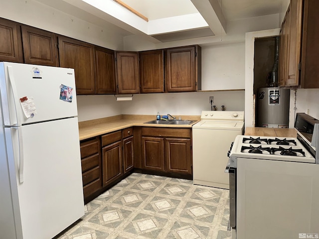 kitchen featuring washer / dryer, white appliances, light countertops, and gas water heater