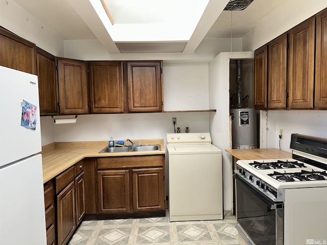 kitchen featuring washer / dryer, white appliances, gas water heater, light countertops, and a sink