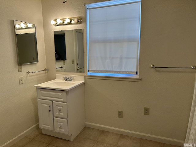 bathroom featuring vanity, baseboards, and tile patterned floors