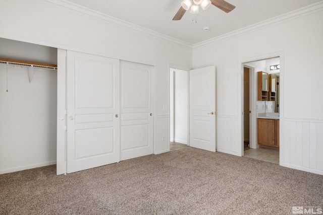 unfurnished bedroom with light carpet, a closet, connected bathroom, and crown molding