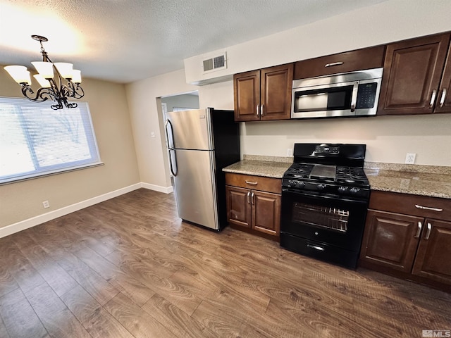 kitchen featuring hanging light fixtures, dark wood-style floors, stainless steel appliances, and dark brown cabinets