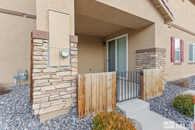 doorway to property with stone siding and stucco siding