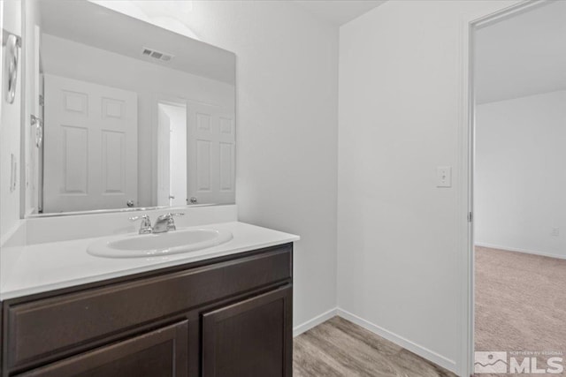 bathroom with vanity, visible vents, and baseboards