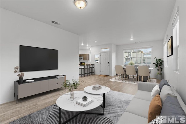 living room featuring recessed lighting, visible vents, and light wood-style flooring