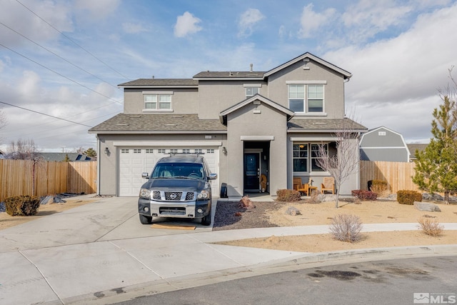 traditional-style home featuring a garage, concrete driveway, fence, and stucco siding