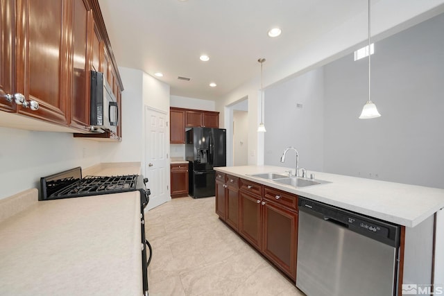 kitchen with appliances with stainless steel finishes, pendant lighting, light countertops, and a sink