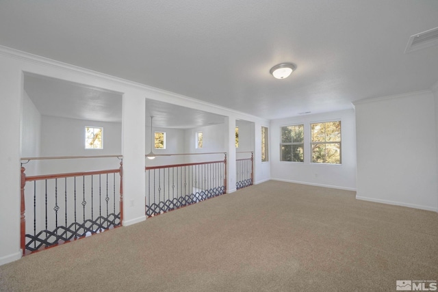 unfurnished room featuring crown molding, carpet, visible vents, and baseboards