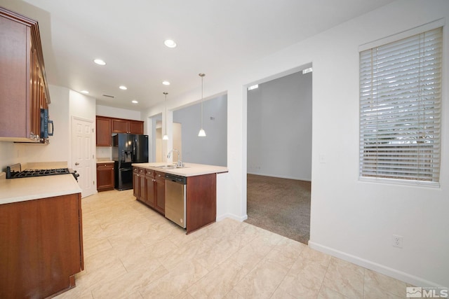 kitchen with a sink, black appliances, light countertops, and pendant lighting