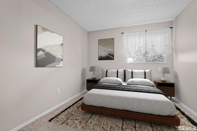 carpeted bedroom with baseboards and a textured ceiling