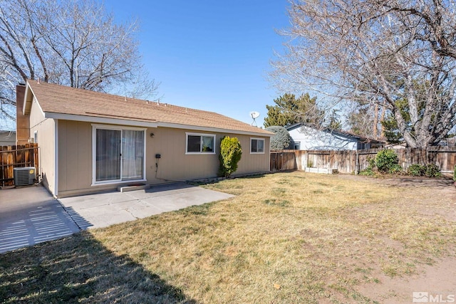 rear view of house featuring a patio area, a yard, and a fenced backyard