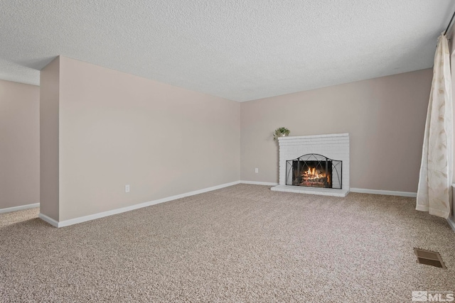 unfurnished living room featuring baseboards, a fireplace, visible vents, and carpet flooring