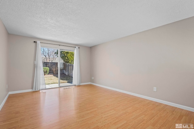 spare room featuring light wood-style flooring and baseboards