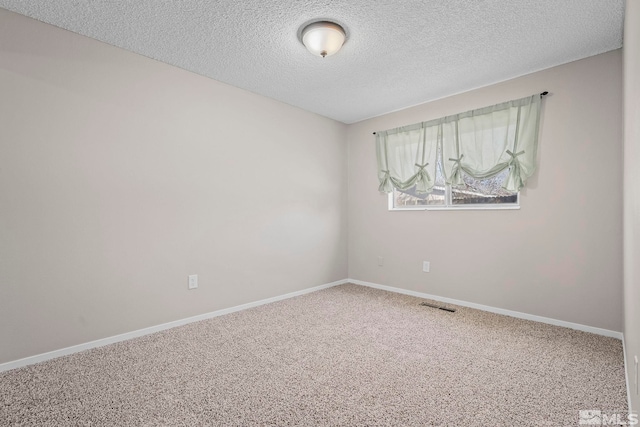 empty room featuring a textured ceiling, carpet floors, visible vents, and baseboards