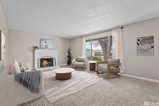 living area featuring a brick fireplace, carpet, baseboards, and a textured ceiling