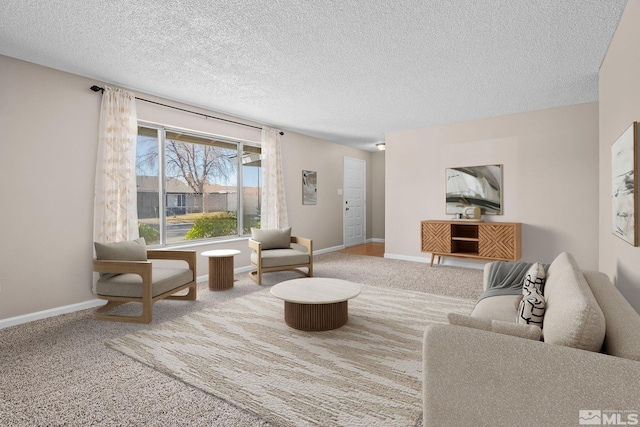 living area featuring a textured ceiling, carpet, and baseboards