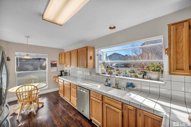 kitchen featuring baseboards, decorative backsplash, appliances with stainless steel finishes, dark wood-style flooring, and a sink