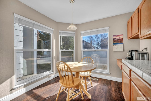 dining area featuring dark wood-style floors, visible vents, and baseboards