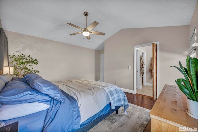 bedroom featuring lofted ceiling, ceiling fan, dark wood-style floors, and baseboards