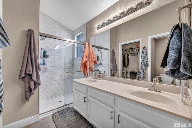 full bath with vaulted ceiling, double vanity, a sink, and a shower stall