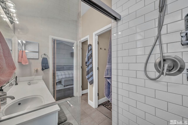 full bathroom with tiled shower, vanity, and tile patterned floors