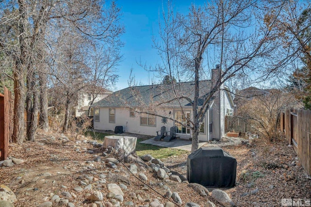 exterior space featuring a patio area, fence, and a chimney