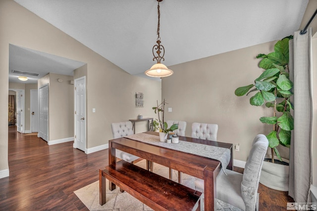 dining space featuring lofted ceiling, baseboards, and wood finished floors