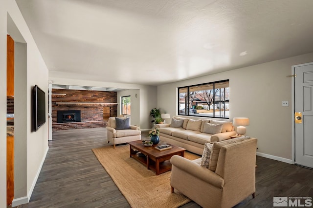 living area with a fireplace, dark wood finished floors, and baseboards