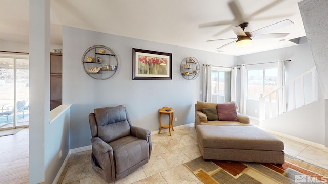 sitting room with ceiling fan, stairway, and baseboards