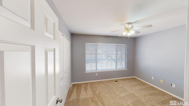 empty room featuring ceiling fan, carpet flooring, and baseboards