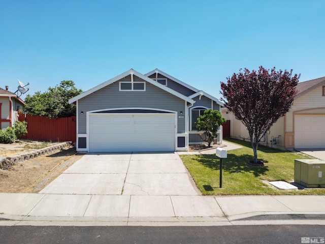 view of front of house with a garage, concrete driveway, a front lawn, and fence