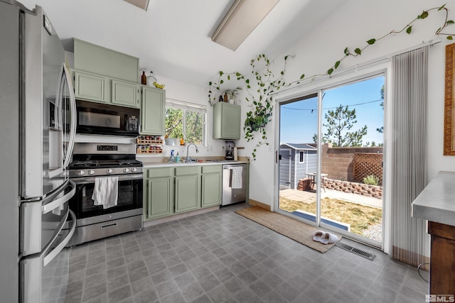 kitchen with appliances with stainless steel finishes, light countertops, green cabinetry, and visible vents