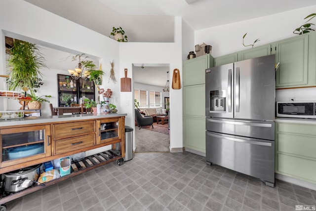 kitchen with light floors, light countertops, a chandelier, stainless steel fridge, and green cabinetry