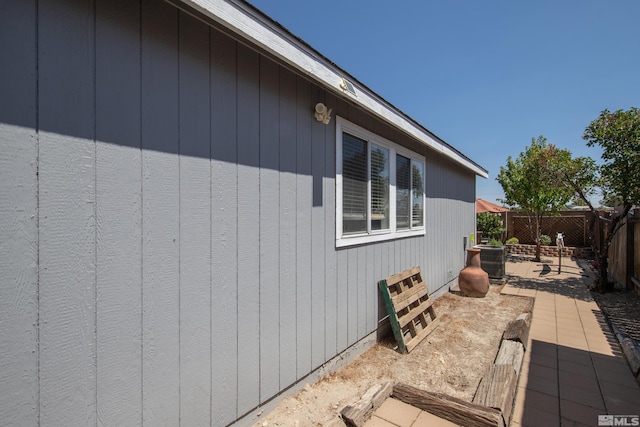 view of side of home featuring central AC and fence