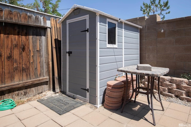 view of shed featuring fence