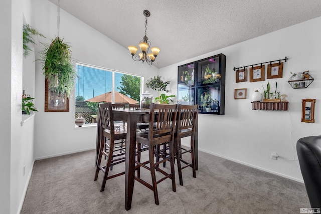 dining space with a chandelier, carpet, vaulted ceiling, and a textured ceiling