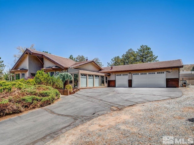 view of front facade featuring an attached garage, concrete driveway, and stucco siding