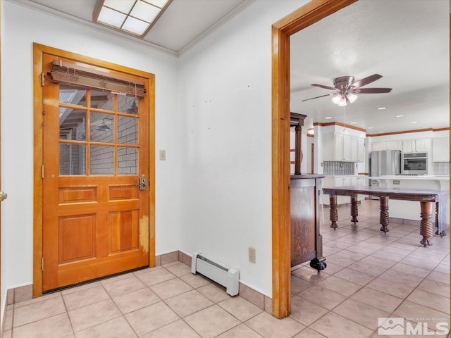 entryway featuring a baseboard heating unit, light tile patterned flooring, and ornamental molding