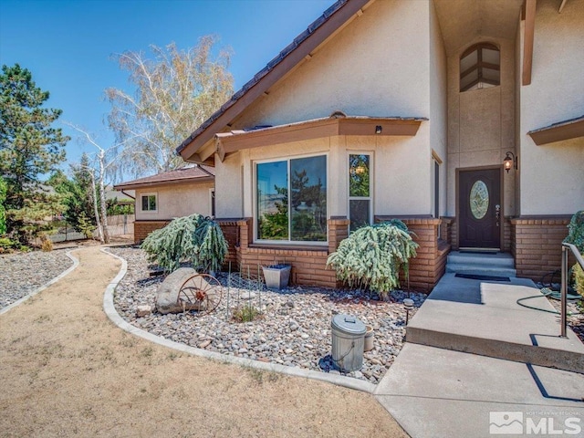 view of front of home featuring stucco siding and brick siding