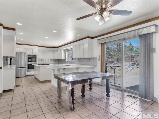 kitchen featuring light countertops, visible vents, decorative backsplash, appliances with stainless steel finishes, and a sink