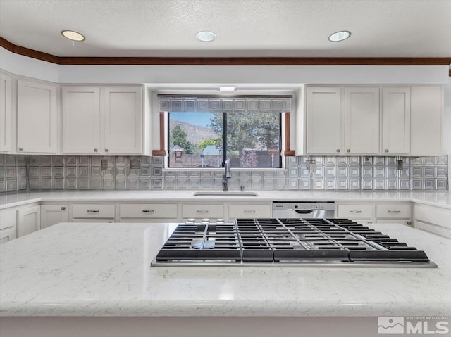 kitchen featuring decorative backsplash, white cabinets, light stone counters, appliances with stainless steel finishes, and a sink