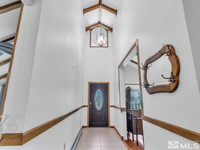 foyer entrance featuring light tile patterned floors, high vaulted ceiling, a baseboard radiator, and baseboards