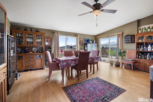 dining area with lofted ceiling, ceiling fan, and light wood-style floors